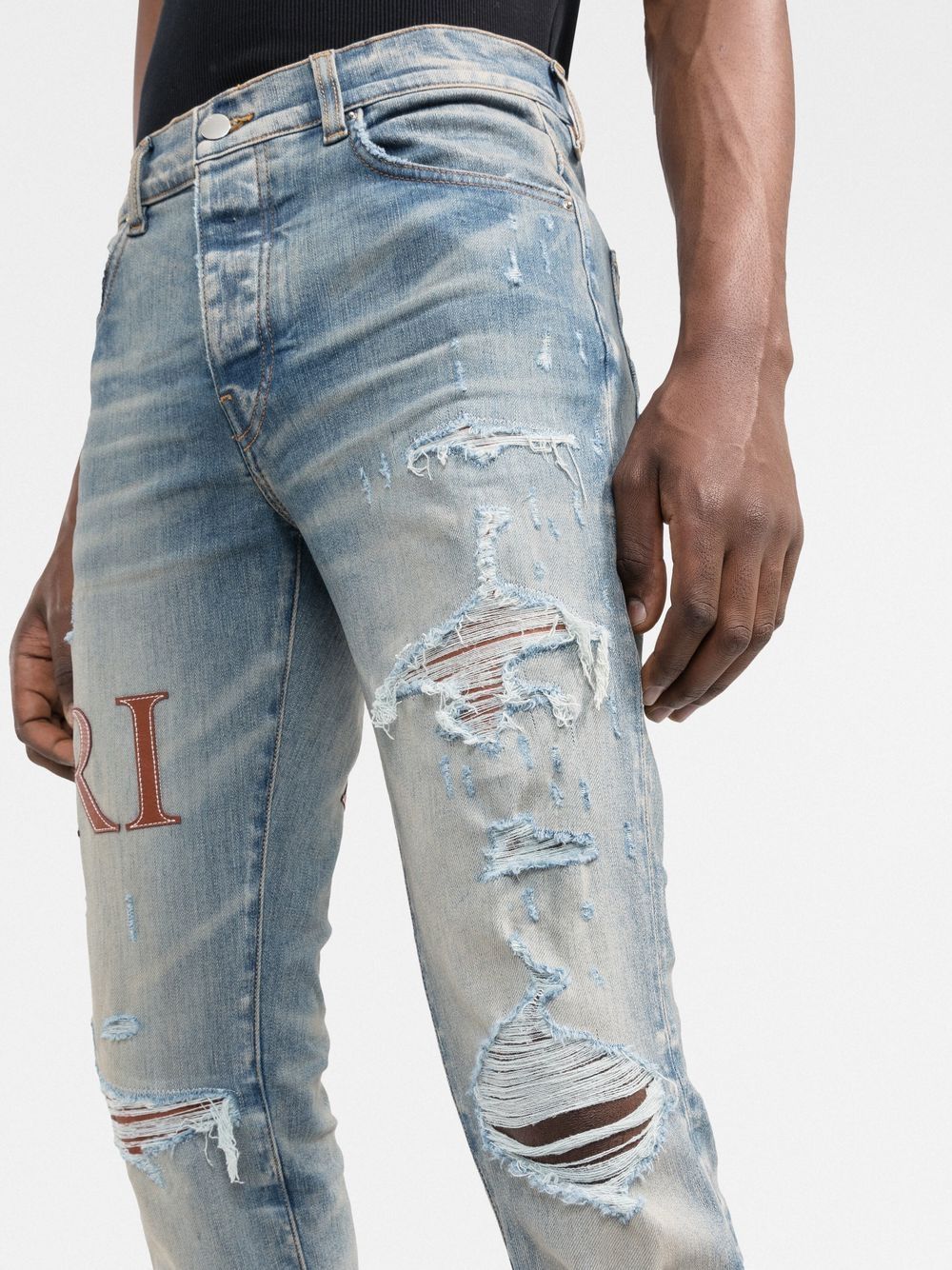 Jean skinny à logo cousu en cuir AMIRI